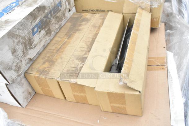 Boxes of scratch and dent items including Sabert clamshells and metal pans. Visible worn packaging indicates condition.