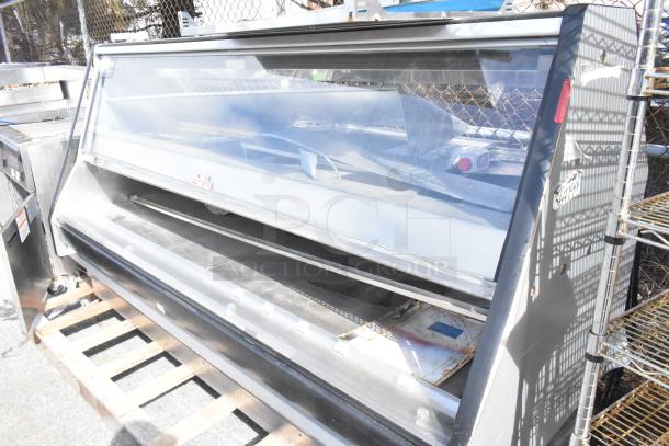 Commercial floor-style warming display case merchandiser with glass front, steel body, moderate wear, and visible user controls.