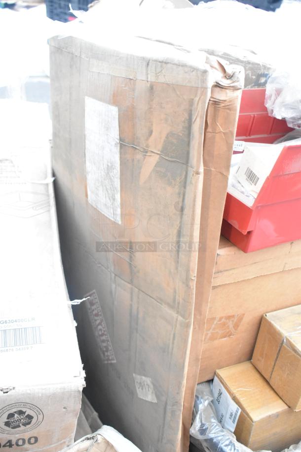 Assorted new scratch and dent items; includes Rubbermaid food container, metal basket, utensils, and plates. Various boxes stacked.