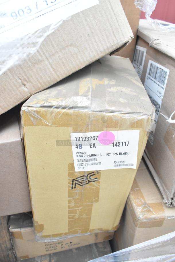 Cardboard boxes of new scratch and dent items, including Rubbermaid container and knives, labeled with item details.