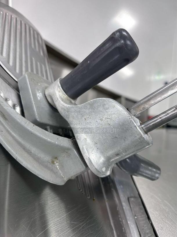 Hobart commercial manual meat slicer, NSF listed, fully operational. Features robust metal construction and ergonomic handle. Made in USA.