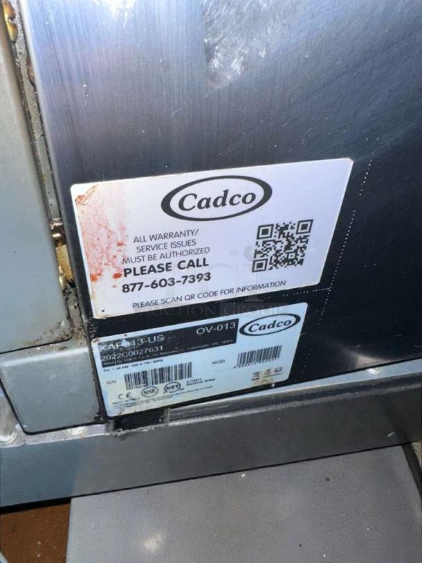 Cadco OV-013/XAF-013-US convection oven. NSF & UL listed. Operational. Service label with QR code visible.