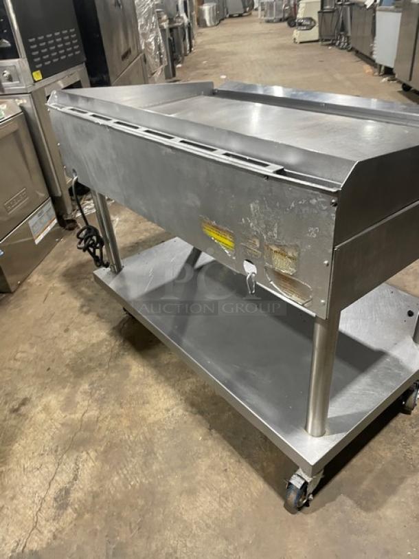 Vulcan stainless steel natural gas griddle on equipment stand with casters, back and side splash, and thermostatic control.