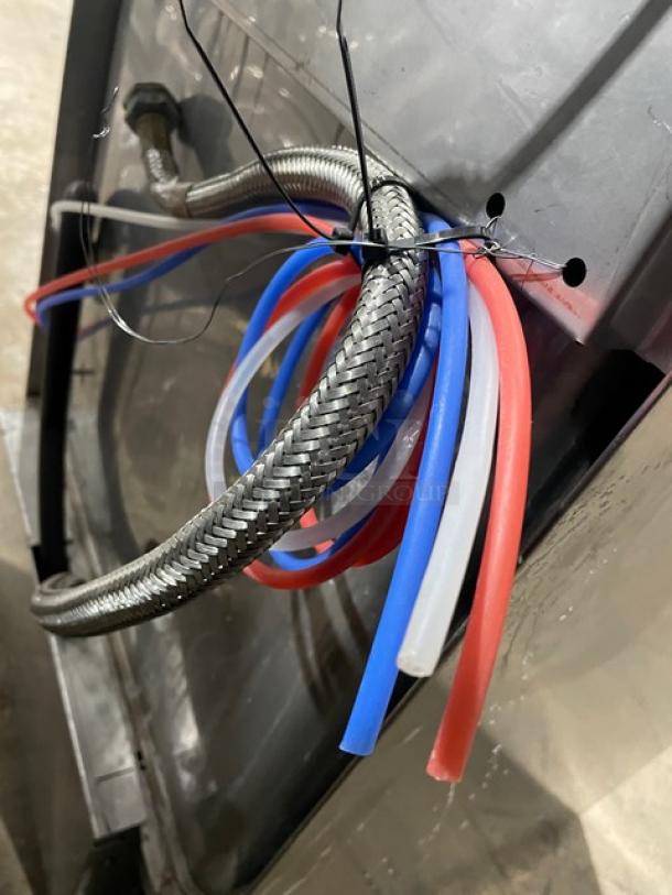Hobart LXEC Advansys dishwasher hoses and wiring; stainless steel braided hose, red, blue, and white tubing visible.