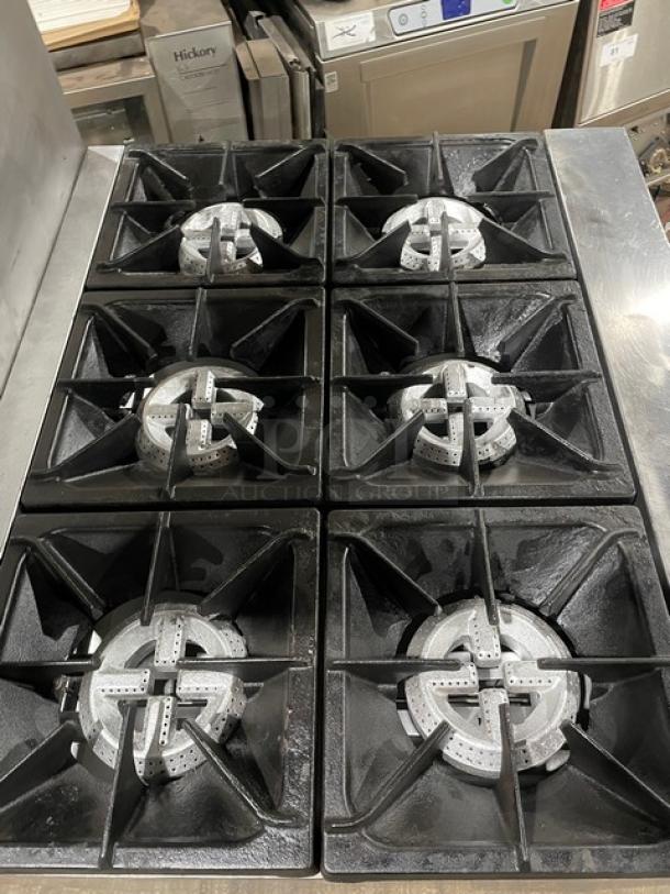 Qualite stainless steel 6-burner range/oven, model QLGR36NG, with backsplash and salamander shelf. Natural gas powered.