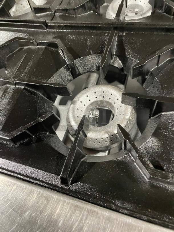 American Range stainless steel 4-burner gas stove burner detail, featuring durable cast iron grates.