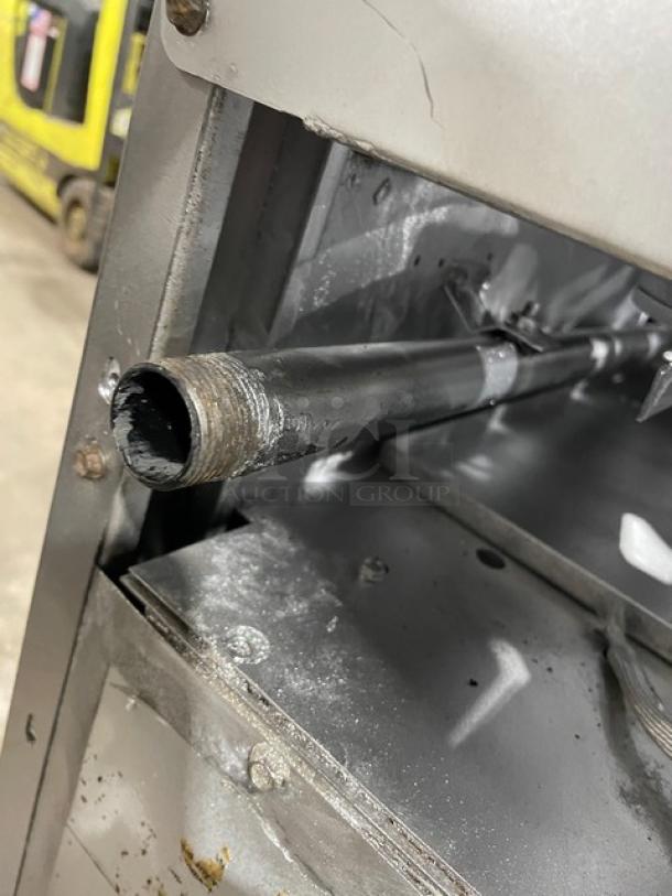 American Range commercial stainless steel 4-burner range/oven combo interior view; shows a pipe, indicating gas connection.