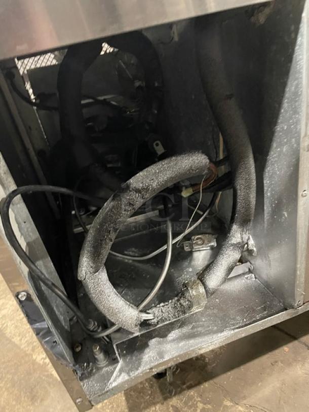 Continental stainless steel 2-drawer refrigerated chef base, visible interior components, on casters, needs maintenance.