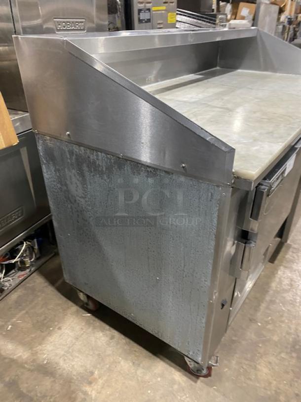 Leader DR60SC 2-door refrigerated pizza prep table with marble worktop, overhead shelf, stainless steel, on casters.