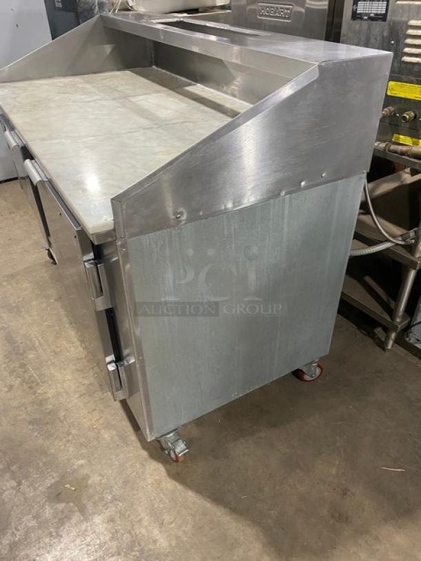 Leader DR60SC stainless steel 2-door refrigerated pizza prep table, marble worktop, overhead shelf, on casters.