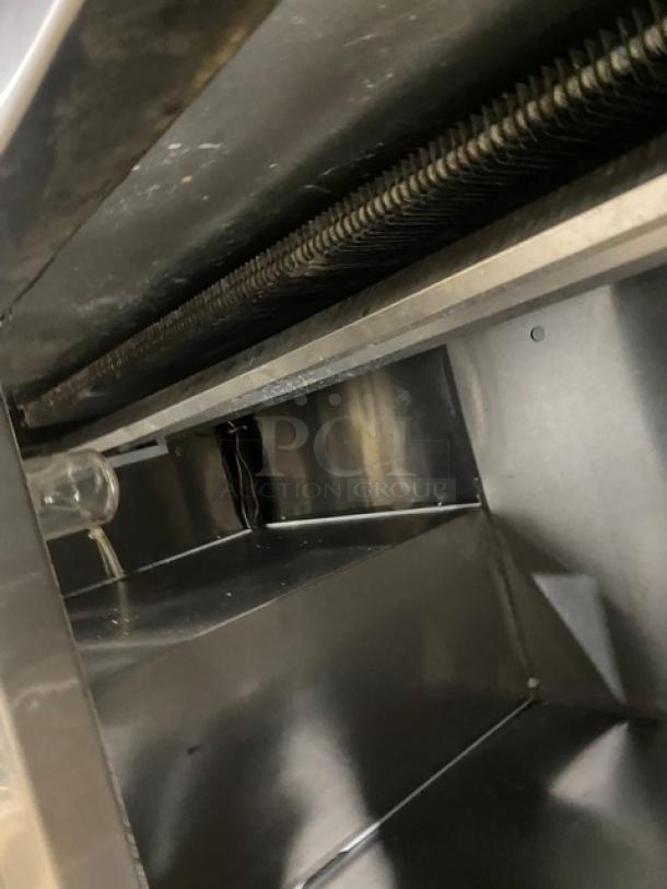 Commercial stainless steel interior of Leader DR60SC refrigerated pizza prep table. Visible shelves and metal details.