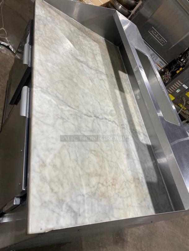 Leader DR60SC refrigerated pizza prep table with marble worktop, overhead shelf, stainless steel build, on casters.