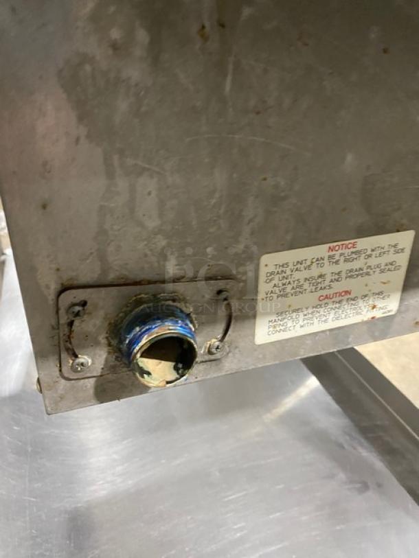 Wells MOD300TDM stainless steel 3-well hot food table with thermostatic controls, visible drain valve and caution notice.