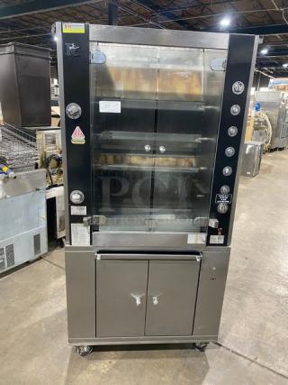 Rotisol commercial stainless steel rotisserie oven, model 9505, with tempered glass doors, enclosed cabinet base, and retractable workstation on casters.