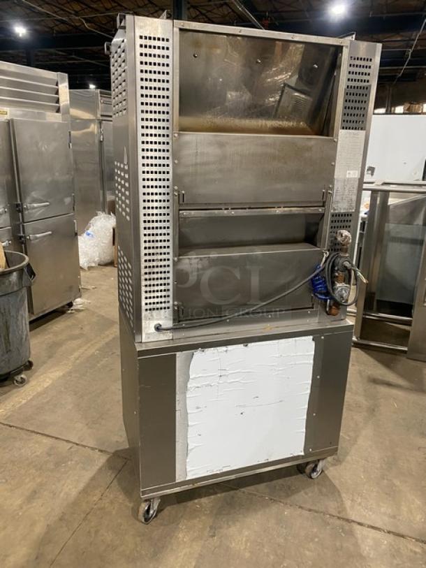 Rotisol Model 9505 commercial stainless steel rotisserie oven with tempered glass doors, enclosed cabinet base, pull-out workstation, on casters.