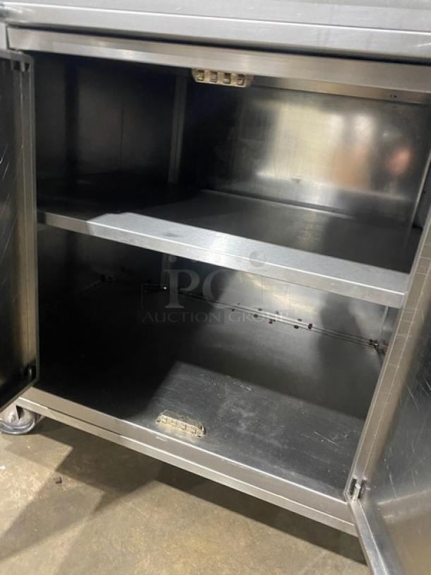Rotisol 9505 stainless steel rotisserie oven cabinet, open doors, interior shelves, on casters, commercial use.