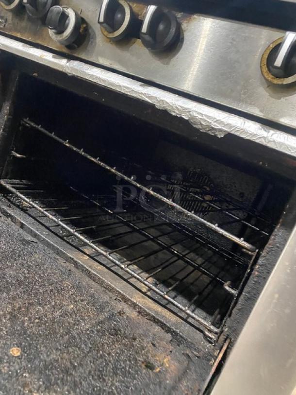 Garland G366C stainless steel 6-burner gas range/oven combo with back splash, salamander shelf, and wired rack. On casters.