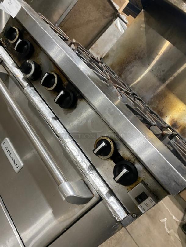 Garland G366C stainless steel 6-burner gas range/oven combo with backsplash, overhead salamander shelf, and wired oven rack.