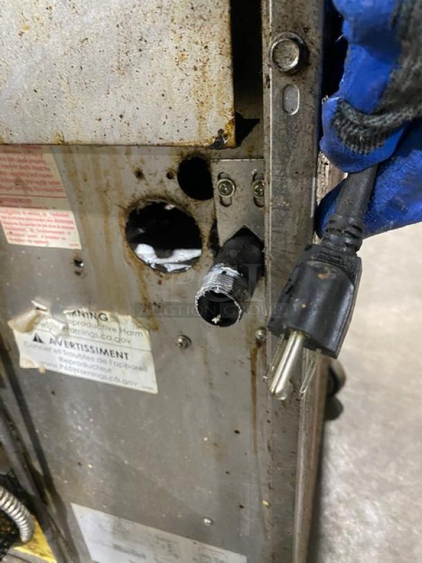 Garland G366C commercial gas range with power plug and worn exterior. Features include 6-burner range and oven combo.