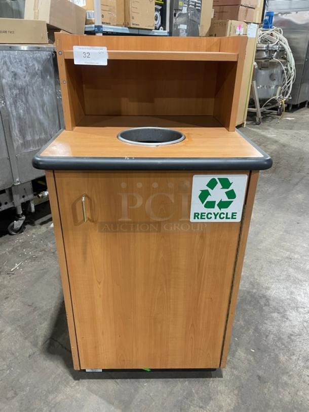 Commercial wooden waste receptacle with recycle symbol, upper serving tray storage, enclosed design, and metal legs.