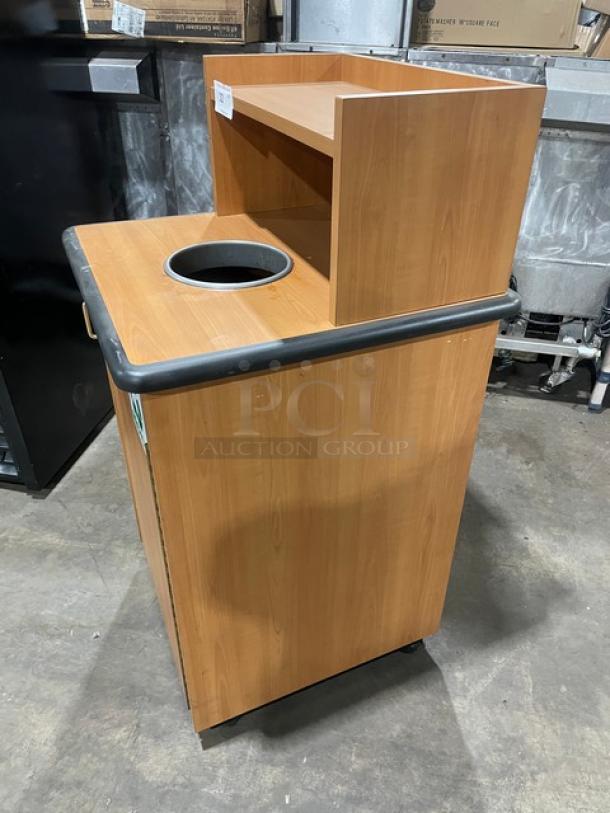 Commercial wooden recycle-style trash receptacle cabinet with upper serving tray storage. Features durable construction and leg supports.