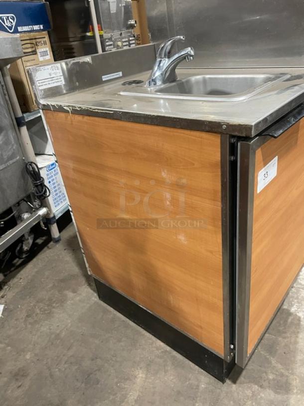 Duke Commercial Stainless Steel Hand Washing Cabinet, Model SUB-PS-24-C M, with back and right-side splash, wood paneling.