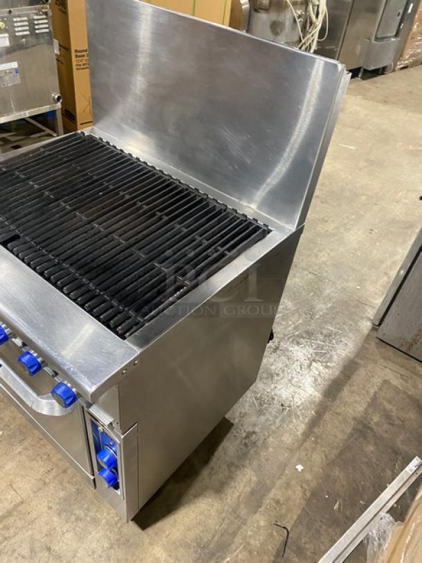 Imperial commercial stainless steel gas char broiler range/oven combo with backsplash, blue knobs, and casters.