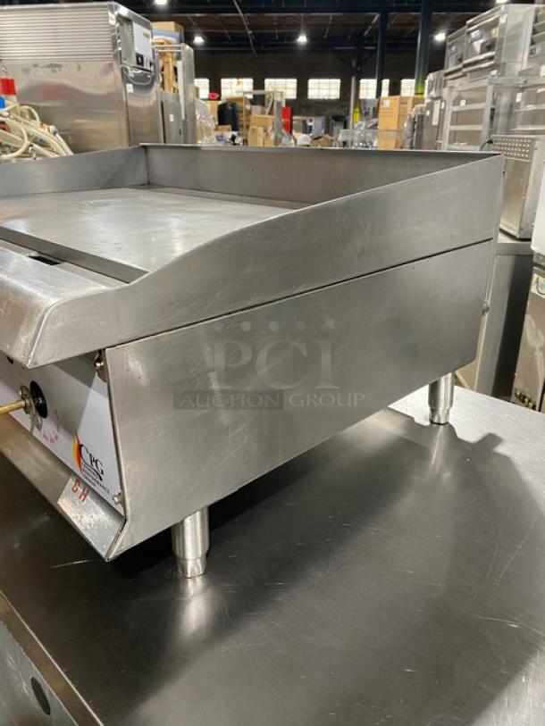 CPG commercial stainless steel gas griddle with thermostatic controls, back and side splash, on legs, in good condition.
