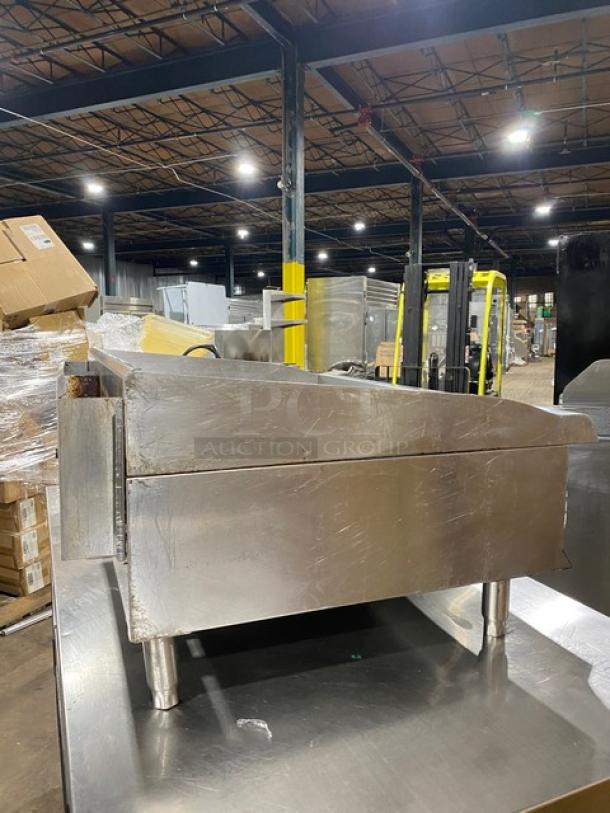 CPG Commercial stainless steel gas countertop flat griddle with thermostatic controls, back and side splash, on legs.