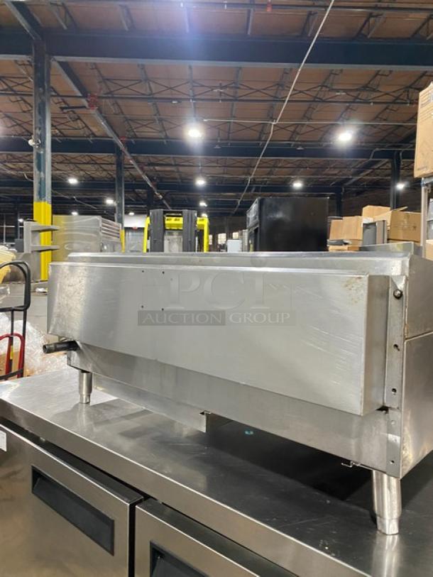 CPG commercial stainless steel gas-powered countertop flat griddle with thermostatic controls, back & side splash, on legs.