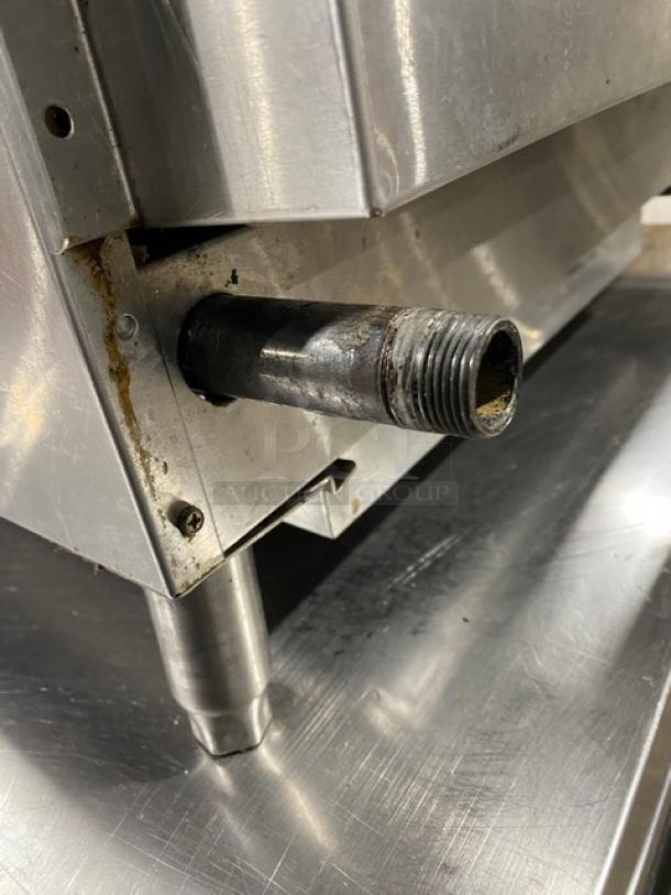 CPG stainless steel gas-powered countertop flat griddle with thermostatic controls, back and side splash, on legs, minor wear.