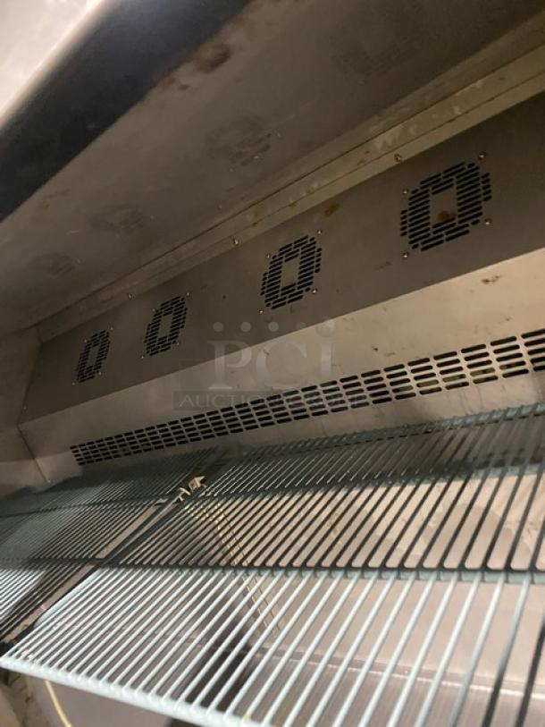 Commercial stainless steel 2-door lowboy cooler with poly-coated wire rack, visible vents, on casters, in good condition.