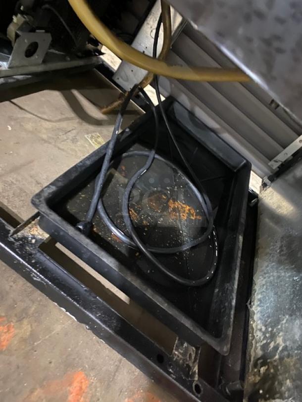 True GDM37 double glass sliding door refrigerator interior view, showing wiring and a drip tray, used condition.