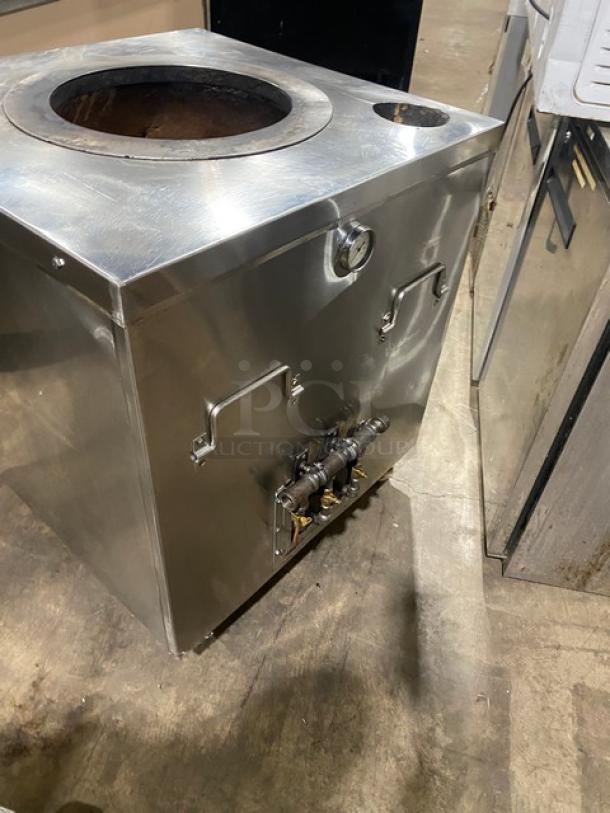 Commercial stainless steel natural gas tandoor oven on casters; features round opening, temperature gauge, and dual handles.