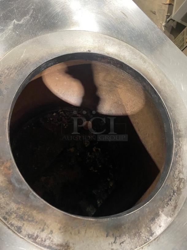 Commercial stainless steel tandoor oven on casters, natural gas powered, slightly worn condition, circular opening.