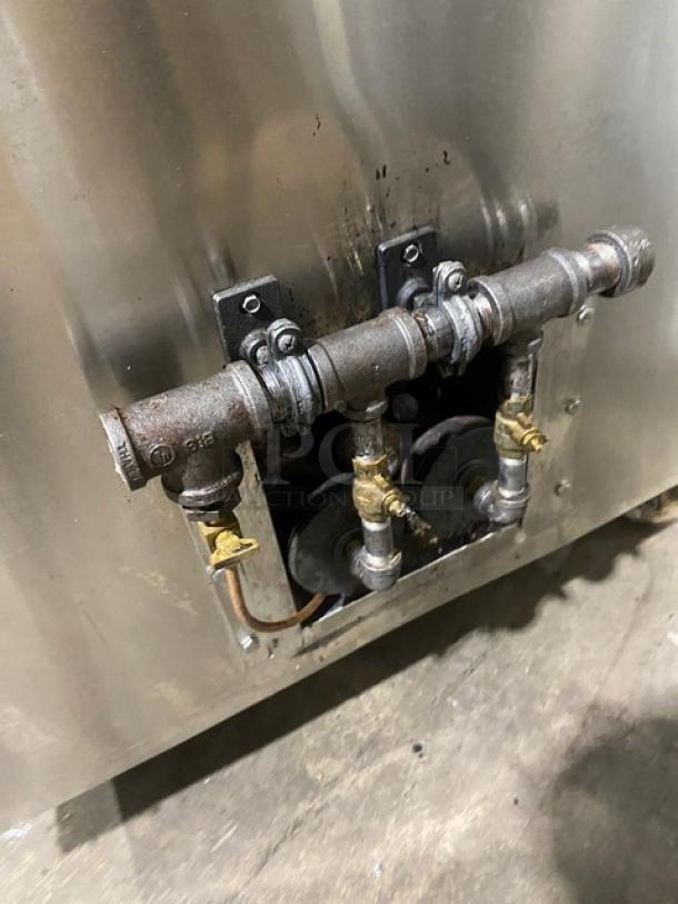 Commercial stainless steel tandoor oven, natural gas powered, on casters. Visible gas connectors and pipes.