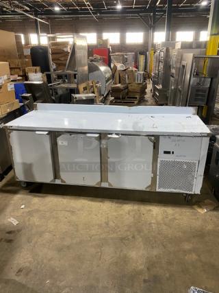 Custom Cool 3-door refrigerated worktop table, model LB93. Features stainless steel, upturned backsplash, pan rack, casters.