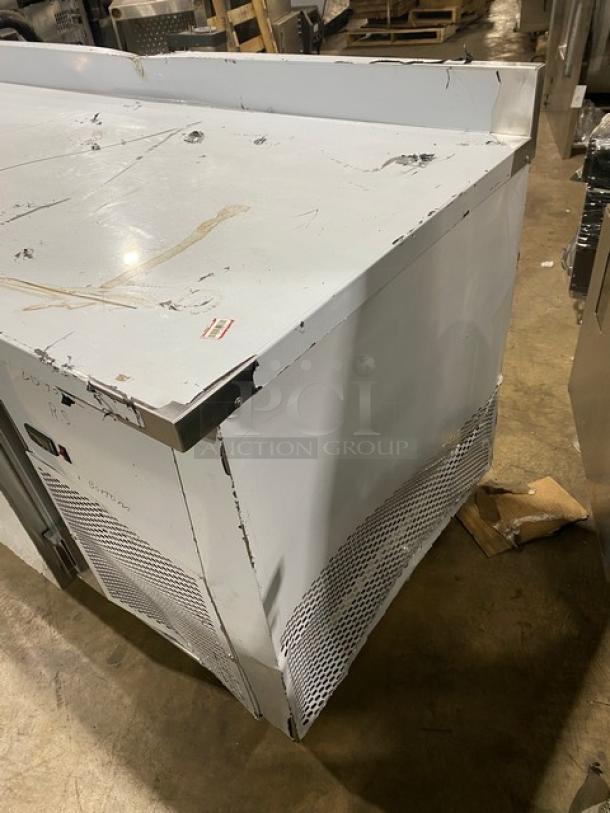 Custom Cool Model LB93 3-door refrigerated stainless steel worktop table with up-turned backsplash, universal pan rack, on casters. Visible wear.