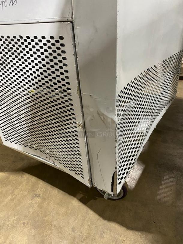 Custom Cool stainless steel refrigerated worktop table, model LB93, with upturned backsplash and universal pan rack. Visible wear and tear on corner, mounted on casters.