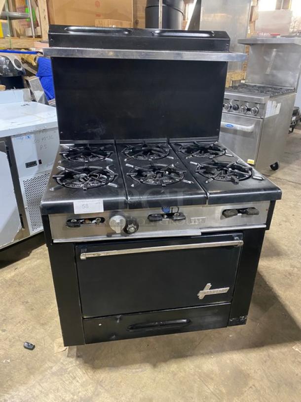 Garland commercial black gas-powered 6-burner range/oven combo with backsplash, overhead salamander shelf, and wired oven rack.
