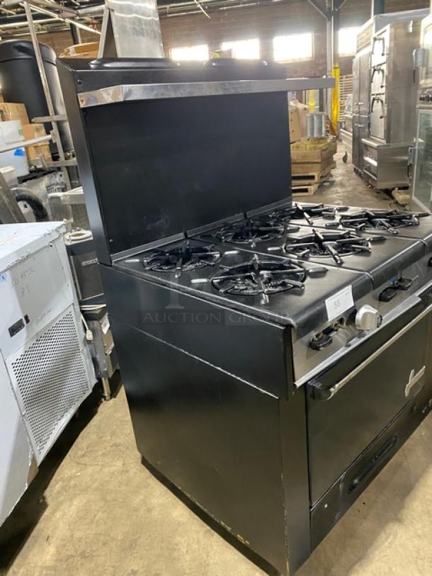 Garland commercial black gas 6-burner range/oven combo with backsplash, overhead salamander shelf, and wired oven rack.