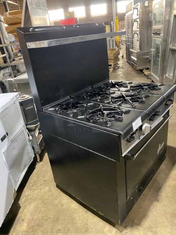 Garland commercial black gas 6-burner range/oven combo with backsplash, overhead salamander shelf, and wired oven rack.
