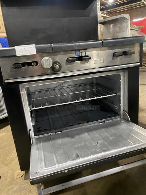 Garland Commercial Black Gas 6-Burner Range/Oven Combo with backsplash, overhead salamander shelf, and wired oven rack.
