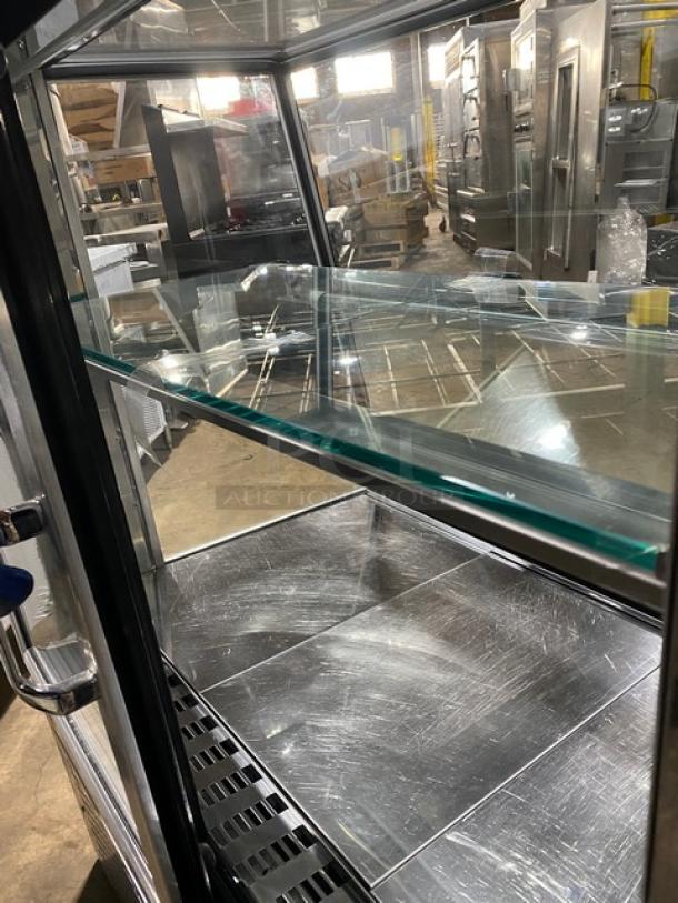 Commercial stainless steel bakery display case, slanted glass, multi-tier, rear sliding glass doors, on legs, gently used.