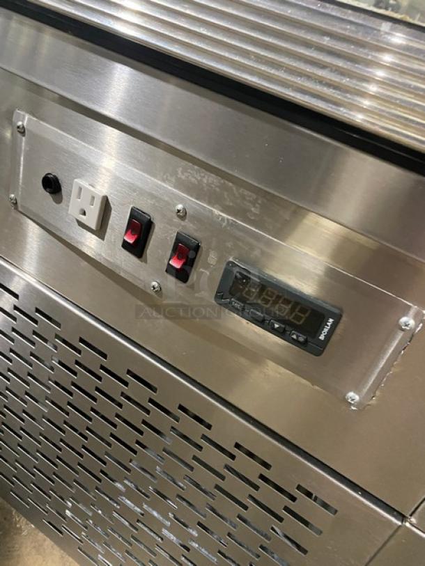 Stainless steel bakery display with digital controls, slanted glass shelves, rear double sliding doors, and sturdy legs.