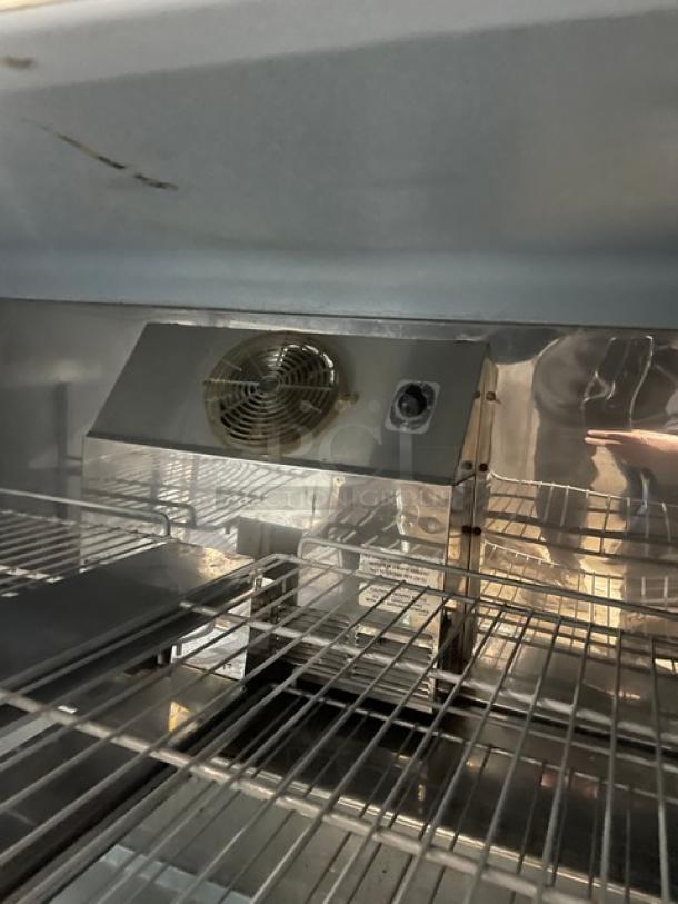 Delfield stainless steel 2-door undercounter refrigerator, model UC4448N-A8, features poly coated wired rack, fan unit, and interior shelving.