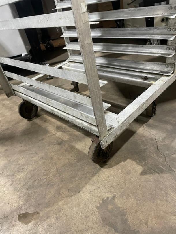 Commercial aluminum 20-pan end-load sheet pan holding/transport rack, showing moderate wear, with casters for mobility.