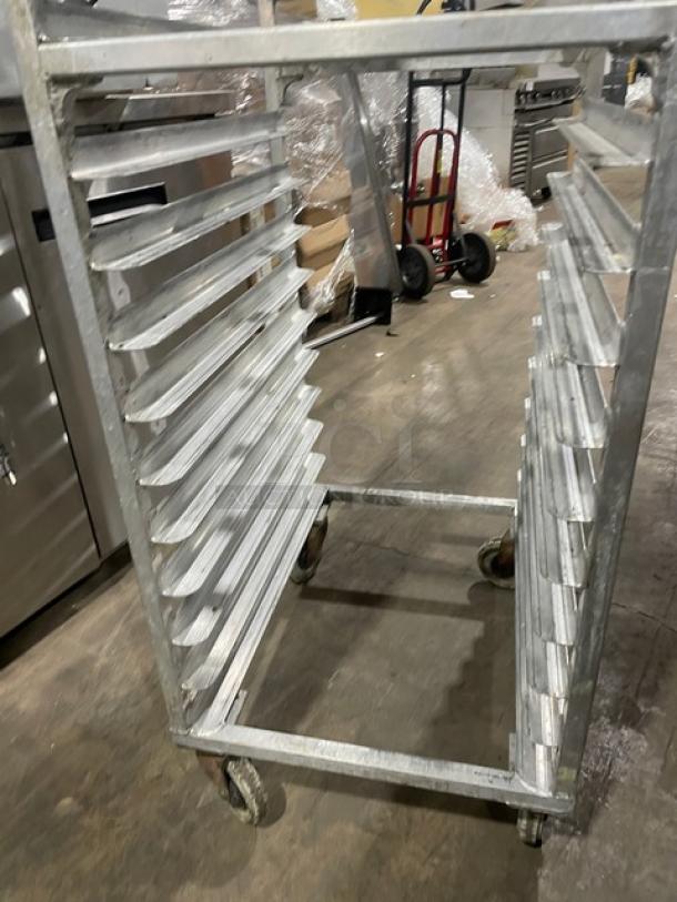 Commercial aluminum full-size heavy duty bun/sheet pan rack on casters, showing signs of use, with 20 slots.