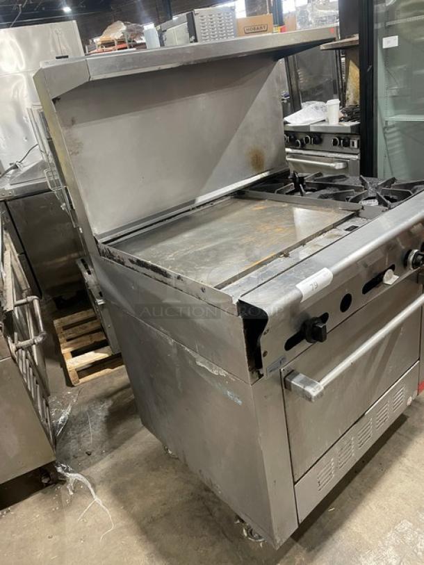 US Range commercial stainless steel 2-burner split-top flat griddle range/oven combo, with backsplash, overhead salamander shelf, and wired oven rack. On casters.