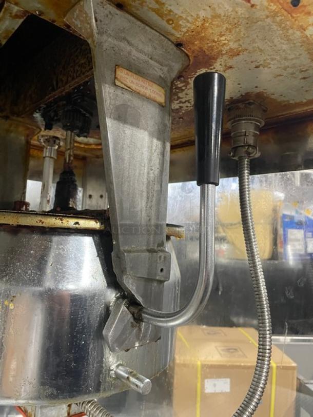 Gold Medal 2010TM popcorn machine in stainless steel, commercial grade. Features a heated corn deck. Visible signs of wear.